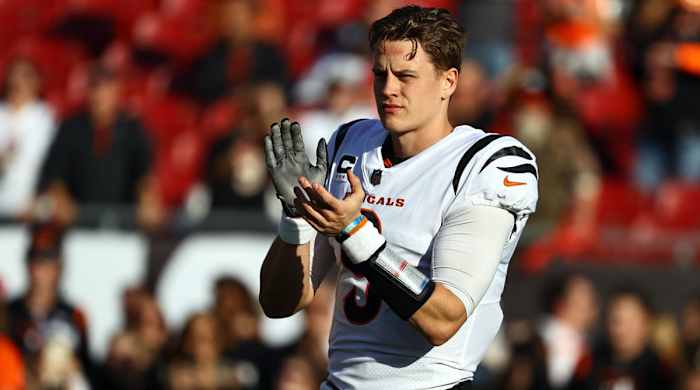 Joe Burrow claps with his helmet off